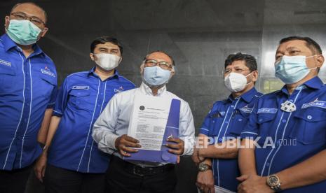 Kepala Badan Komunikasi Strategis DPP Partai Demokrat Herzaky Mahendra Putra (kedua kiri) bersama kuasa hukum DPP Partai Demokrat Bambang Widjojanto (tengah) surat gugatan saat mengajukan gugatan perbuatan melawan hukum di Pengadilan Negeri (PN) Jakarta Pusat di Jakarta, Jumat (12/3/2021). DPP Partai Demokrat melakukan gugatan terkait dengan pelaksanaan Kongres Luar Biasa (KLB) di Sibolangit, Deli Serdang, Sumatera Utara. 