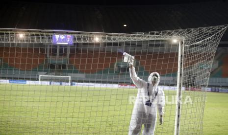 Petugas menyemprotkan cairan disinfektan saat pertandingan laga Liga 1 antara Persita lawan Persipura di Stadion Pakansari, Kabupaten Bogor, Jawa Barat, Sabtu (28/8/2021). Ketua Umum PSSI Mochamad Iriawan mengatakan selain protokol kesehatan (prokes) yang ketat, seluruh pemain, ofisial serta panitia pelaksana yang terlibat di stadion telah menjalani vaksinasi. 