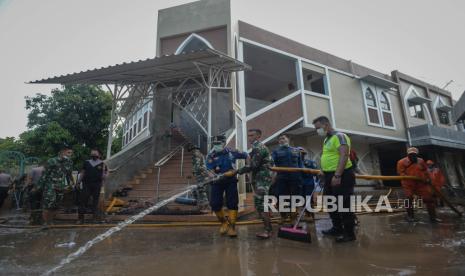 Personel gabungan dari TNI, Polri, petugas Pemadam Kebakaran, PPSU, dan warga sekitar membersihkan endapan lumpur sisa banjir di area Masjid Al-Hidayah, Cipinang Melayu. Jakarta Timur, Senin (22/2). Kegiatan kerja bakti tersebut dilakukan diarea tempat ibadah agar dapat digunakan kembali untuk beribadah. Republika/Thoudy Badai