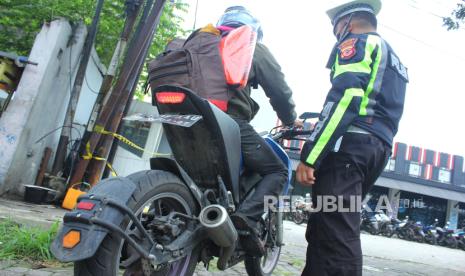 Petugas kepolisian menghentikan pengendara sepeda motor saat razia knalpot brong atau knalpot bising di Jalan Pelajar Pejuang, Kota Bandung, Jawa Barat, Kamis (11/1/2024). 