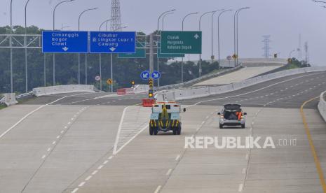 Dua mobil proyek melintasi jalan tol Cimanggis-Cibitung di Depok, Jawa Barat, Minggu (8/11/2020). Kementerian Pekerjaan Umum dan Perumahan Rakyat (PUPR) bersama Badan Pengatur Jalan Tol (BPJT) akan melakukan uji coba pengoperasian jalan tol Cimanggis-Cibitung seksi I pada (10/11) tanpa tarif untuk mensosialisasi kepada masyarakat hingga akhir November 2020. 