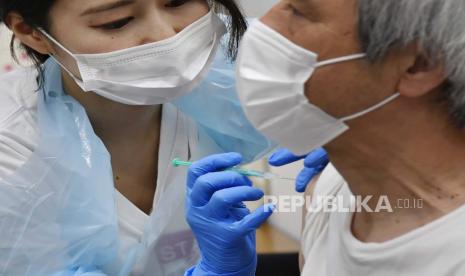 Seorang pria menerima vaksin Pfizer COVID-19 di Stadion Noevir Kobe di Kobe, Jepang bagian barat.