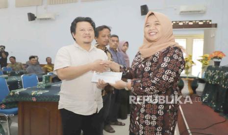 Bupati Sleman, Kustini Sri Purnomo menyerahkan secara simbolis bantuan kepada 59 warga terdampak bencana, di Aula Oproom Dinas PMK Kabupaten Sleman, Senin (24/7/2023).