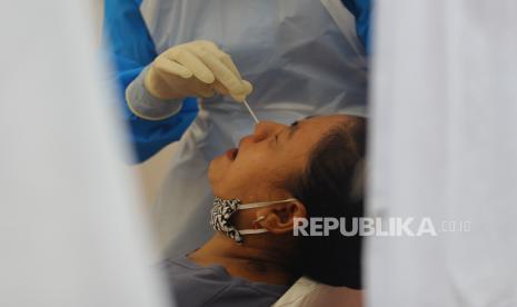 Petugas kesehatan mengambil sampel lendir dari hidung salah satu warga saat mengikuti swab test. ilustrasi