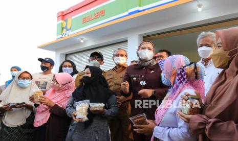 Bupati Indramayu Nina Agustina (empat kanan) berbincang dengan pelaku UMKM di Rumah Produksi dan Galeri UMKM Desa Karangsong, Indramayu, Jawa Barat, Selasa (12/10/2021).  Rumah Produksi dan Galeri UMKM yang dibangun melalui Program Padat Karya Tunai Kota Tanpa Kumuh (KOTAKU) Kementerian PUPR menampung berbagai macam makanan olahan ikan produksi masyarakat yang tinggal di kawasan pesisir. 