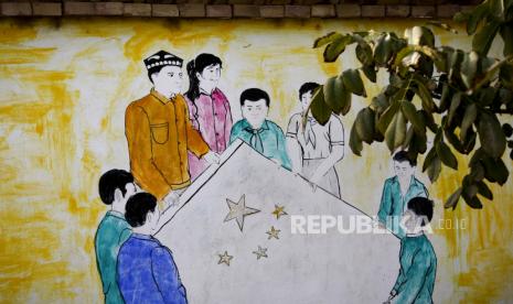 Mantan Rabi Yahudi Inggris Kecam Penindasan Muslim Uighur.. Sebuah mural yang menggambarkan pria dan wanita Cina Uighur dan Han membawa bendera nasional Tiongkok, menghiasi dinding sebuah rumah di Unity New Village, Hotan, Xinjiang. Pakar dari luar mengatakan bahwa kampanye pengendalian kelahiran pemerintah untuk minoritas Muslim adalah bagian dari upaya yang lebih luas untuk secara paksa mengasimilasi populasi Uighur dan Kazakh dan mengubah budaya, bahasa dan identitas mereka.(AP Photo/Andy Wong)