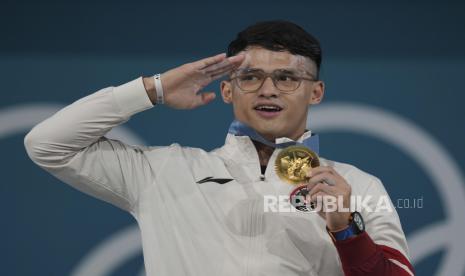 Lifter Indonesia Rizki Juniansyah berpose dengan medali emasnya saat upacara pengalungan medali kelas 73 kg putra Olimpiade Paris 2024 di South Paris Arena, Paris, Prancis, Kamis (8/8/2024). Rizki meraih medali emas setelah berhasil meraih total angkatan 354 kilogram sehingga menduduki peringkat pertama dari 12 lifter yang turut serta dalam nomor tersebut.