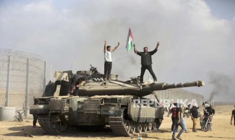 Warga Palestina di atas tank Israeli di Khan Younis.