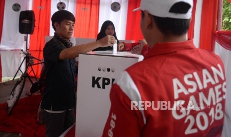 Warga memasukan surat suara ke kotak suara saat pencoblosan di TPS 26 yang betemakan Asian Games 2018, Kranji, Bekasi Barat, Jawa Barat, Rabu (27/6).