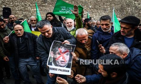 Para pengunjuk rasa mencoba membakar foto politikus sayap kanan Swedia-Denmark Rasmus Paludan di depan Konsulat Jenderal Swedia selama protes di Istanbul, Turki, 22 Januari 2023. Politikus sayap kanan Swedia-Denmark Rasmus Paludan diizinkan menggelar demonstrasi dan membakar mushaf Alquran di depan kedutaan Turki di Stockholm pada 21 Januari 2023.