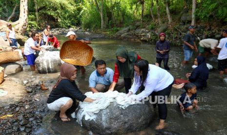 Warga bergotong royong mencuci lawon atau kain kafan di Sungai pada ritual resik lawon di Cungking, Banyuwangi, Jawa Timur, Ahad (25/2/2022). Tradisi resik lawon yang digelar setiap bulan Ruwah pada penanggalan Jawa secara  turun-temurun oleh warga Suku Osing itu untuk mensucikan diri jelang menghadapi bulan suci Ramadhan. 