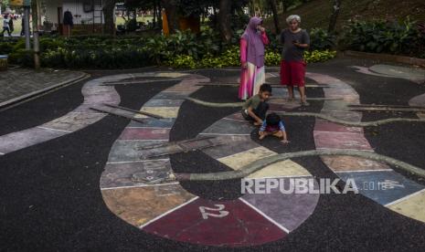 Orang tua mendampingi anaknya bermain ular tangga di Taman Kaulinan, Sempur, Kota Bogor, Jawa Barat, Sabtu (9/7/2022). Taman Sempur merupakan salah satu ruang publik yang dijadikan destinasi wisata alternatif bagi masyarakat untuk mengisi waktu liburan bersama keluarga pada Hari Raya Idul Adha. Republika/Putra M. Akbar