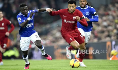 Pemain Liverpool Cody Gakpo (kanan) berlari dengan bola dibayangi pemain Everton Idrissa Gueye (kiri)pada pertandingan sepak bola Liga Utama Inggris antara Liverpool FC dan Everton FC di Liverpool, Inggris, Selasa (14/2/2023) dini hari WIB.