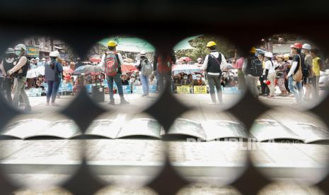 Demonstran terlihat dari lubang perisai saat protes terhadap kudeta militer di Yangon, Myanmar, Kamis (18/3). Protes anti kudeta terus berlanjut meski diintensifkan tindakan keras terhadap demonstran oleh aparat keamanan.