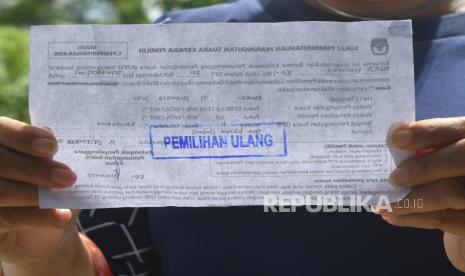 Pemilih menunjukan surat panggilan memilih saat mengikuti pelaksanaan pemungutan suara ulang (PSU) di TPS 11, Desa Kalukubula, Kecamatan Sigi Biromaru, Kabupaten Sigi, Sulawesi Tengah, Minggu (13/12/2020). Sebanyak empat TPS di Kabupaten Sigi melaksanakan PSU setelah ditemukan adanya pelanggaran pada pelaksanaan pemungutan suara 9 Desember 2020 lalu. 