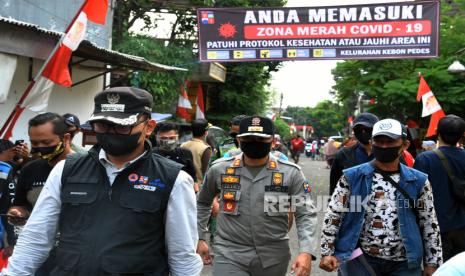 Wali Kota Bogor Bima Arya (kiri) mengunjungi wilayah zona merah penyebaran COVID-19 di GG Pacilong RW 04, Kelurahan Kebon Pedes, Tanah Sareal, Kota Bogor, Jawa Barat, Ahad (30/8/2020). Pemerintah Kota Bogor menerapkan Pembatasan Sosial Berskala Mikro dan Komunitas (PSBMK) termasuk pemberlakuan jam malam dan pembatasan aktivitas warga di 104 RW yang masuk zona merah penyebaran COVID-19 di Kota Bogor. 