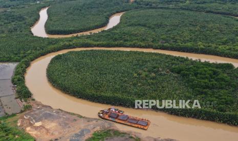 Foto udara sebuah kapal tongkang pengangkut material logistik untuk proyek pembangunan Ibu Kota Negara (IKN) Nusantara kandas di pelabuhan masyarakat Desa Bumi Harapan, Kecamatan Sepaku, Kabupaten Penajam Paser Utara, Kalimantan Timur, Jumat (24/2/2023). Pelabuhan yang menjadi salah satu jalur pengiriman material dan logistik untuk pembangunan IKN Nusantara tersebut mengalami kendala ketika air sungai surut yang mengakibatkan kapal rawan kandas. 