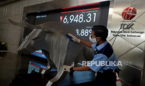 Petugas kebersihan beraktivitas di dekat layar pergerakan Indeks Harga Saham Gabungan (IHSG), Bursa Efek Indonesia, Jakarta. Pasar modal Indonesia pada 2021 mulai mengalami pemulihan dan terus bertumbuh. Hal ini terlihat pada akhir 2021 yang ditutup oleh kinerja positif Indeks Harga Saham Gabungan (IHSG) mencapai posisi 6.581,5 atau naik 10,1 persen (yoy), setelah mengalami penurunan pada masa pandemi tahun 2020.