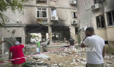 Israelis inspect a damaged residential building after it was hit by a rocket fired from the Gaza Strip, in Ashkelon, Israel, Monday, Oct. 9, 2023. The militant Hamas rulers of the Gaza Strip carried out an unprecedented, multi-front attack on Israel at daybreak Saturday, firing thousands of rockets as dozens of Hamas fighters infiltrated the heavily fortified border in several locations by air, land, and sea, killing hundreds and taking captives. Palestinian health officials reported scores of deaths from Israeli airstrikes in Gaza.