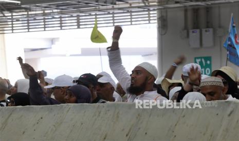 Seorang pria Muslim melempar batu kerikil saat menjalankan lempar Jumroh.