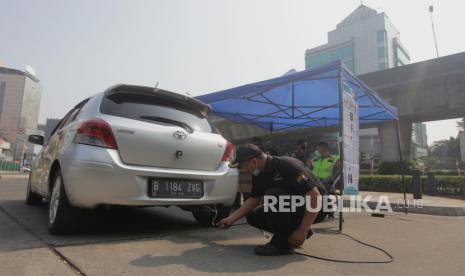 Petugas melakukan uji emisi kendaraan mobil yang terjaring uji coba tilang uji emisi di Terminal Blok M, Jakarta Selatan, Jumat (25/8/2023). Pemerintah Provinsi DKI Jakarta bersama Polda Metro Jaya melakukan uji coba tilang uji emisi di lima wilayah DKI Jakarta sebelum diberlakukan sanksi tilang pada 1 September 2023. Denda sanksi tilang bagi kendaraan yang tidak lulus uji emisi sebesar Rp 250.000 bagi kendaraan motor dan Rp 500.000 bagi kendaraan mobil.