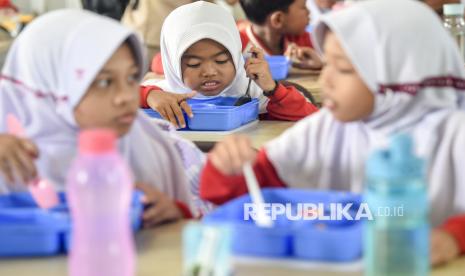 Sejumlah siswa menyantap makanan dari pembagian Makanan Bergizi Gratis (MBG) di SDN 004 Samarinda Utara, Samarinda, Kalimantan Timur, Senin (20/1/2025).  