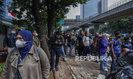 Orang-orang memeriksa ponsel mereka saat berada di luar di tengah kekhawatiran gempa susulan menyusul gempa bumi di kawasan bisnis di Jakarta, Indonesia, 08 Desember 2022. Menurut Badan Meteorologi Indonesia (BMGK), gempa berkekuatan 5,8 melanda tenggara Sukabumi, provinsi Jawa Barat. Gempa dirasakan di gedung-gedung bertingkat di ibu kota dan memaksa para pekerja dievakuasi.