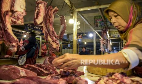 Pedagang melayani pembeli daging sapi di Pasar Kosambi, Kota Bandung, Jumat (25/2/2022). Berdasarkan keterangan pedagang, sejak sepekan terakhir harga daging sapi di pasar tersebut mengalami kenaikan hingga Rp130 ribu per kilogram. Kenaikan tersebut berdampak pada turunnya daya beli masyarakat dan menurunnya omzet pedagang hingga 50 persen. 