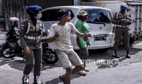 Petugas Satpol PP Kota Bandung menghentikan pengendara yang tidak memakai masker saat Operasi Disiplin Adaptasi Kebiasaan Baru (AKB) di Jalan Astana Anyar, Kota Bandung, Jumat (20/11). Operasi tersebut digelar dalam rangka peningkatan kedisiplinan masyarakat untuk mematuhi protokol kesehatan Covid-19 pada masa adaptasi kebiasaan baru (AKB). Foto: Abdan Syakura/Republika