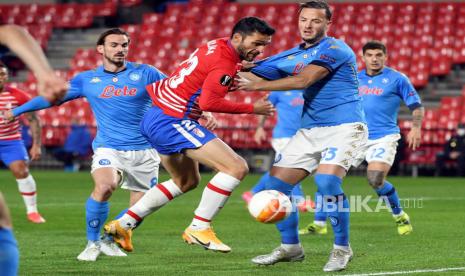 Striker Granada Jorge Molina (tengah) berduel memperebutkan bola dengan bek Napoli Amir Rrahmani (kanan) dan gelandang Fabian Ruiz (kiri) selama pertandingan sepak bola leg pertama babak 32 besar Liga Eropa UEFA antara Granada FC dan SSC Napoli yang diadakan di stadion Los Carmenes di Granada, Spanyol selatan, 18 Februari 2021.