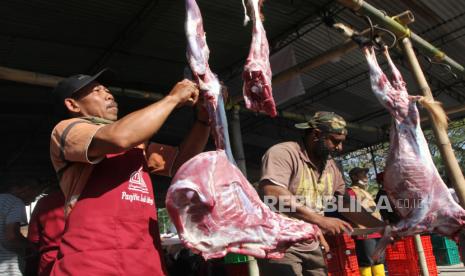 Relawan membantu memotong daging hewan kurban saat perayaan Hari Raya Idul Adha di depan masjid Ihyaul Qulub  di Tirtasani, Karangploso, Malang, Jawa Timur, Ahad (10/7/2022). Panitia pemotongan hewan kurban setempat berupaya menghadapi wabah Penyakit Mulut dan Kuku (PMK) dengan menggandeng dokter hewan serta mendatangkan Juru Sembelih Halal (Juleha) bersertifikasi untuk memastikan kesehatan dan kehalalan daging hewan kurban sebelum dibagikan ke masyarakat. 