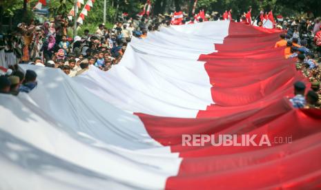 Personel gabungan TNI Polri membawa bendera merah putih berukuran 5x100 meter saat Kirab Bendera Merah Putih di Cibinong, Kabupaten Bogor, Jawa Barat, Kamis (12/10/2023). Kirab Merah Putih tersebut merupakan salah satu rangkaian acara Maulid Akbar Nabi Besar Muhammad SAW dan Tausiah Kebangsaan 1445 H/2023 M di Bogor. 