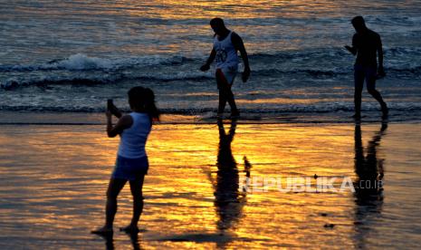 Wisatawan mengunjungi kawasan Pantai Kuta, Badung, Bali, Kamis (9/7/2020). Pengelola Pantai Kuta mulai membuka kembali kawasan yang merupakan salah satu destinasi pariwisata utama di Pulau Dewata tersebut setelah sebelumnya sempat ditutup selama lebih dari tiga bulan sebagai upaya pencegahan penyebaran pandemi COVID-19. 