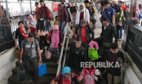 Penumpang kereta api Jayabaru  menuruni tangga pintu keluar di stasiun Kereta api Senen Jakarta, Kamis (21/2).