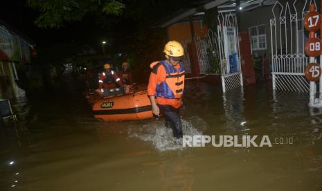 Tim SAR berjalan melewati jalan yang terendam banjir saat akan mengevakuasi warga di Perumnas Sudiang, Makassar, Sulawesi Selatan, Jumat (18/11/2022). Hujan dengan intensitas tinggi yang mengguyur Kota Makassar mengakibatkan banjir di sejumlah pemukiman dan ruas jalan. 