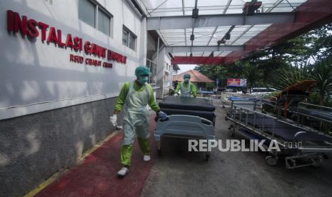 Petugas tenaga kesehatan membawa tempat tidur pasien yang telah dibersihkan di depan Instalasi Gawat Darurat (IGD) 