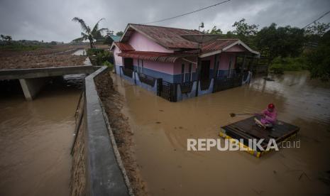 Warga menggunakan perahu rakit di depan rumahnya yang terendam banjir di Tembesi Tower, Batam, Kepulauan Riau, Rabu (4/9/2024). Banjir setinggi 30 cm hingga 1 meter yang disertai lumpur tersebut disebabkan oleh proyek pembangunan kawasan industri yang menutupi jalur air permukiman warga di daerah itu sejak enam bulan terakhir. 