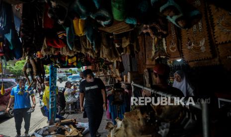 Pengunjung memilah pernak pernik khas Papua di Pasar Central Hamadi, Kota Jayapura, Papua, Kamis (14/10). Menjelang penutupan PON XX Papua pada Jumat 15 Oktober 2021, Pasar Central Hamadi mulai dipadati sejumlah pengunjung dan kontingen PON untuk membeli oleh-oleh khas Papua seperti noken, gelang bambu, hiasan dinding kulit kayu, koteka, dan lainnya yang dibandrol mulai dari harga Rp 5 ribu hingga jutaan rupiah, tergantung jenis dan ukuran.