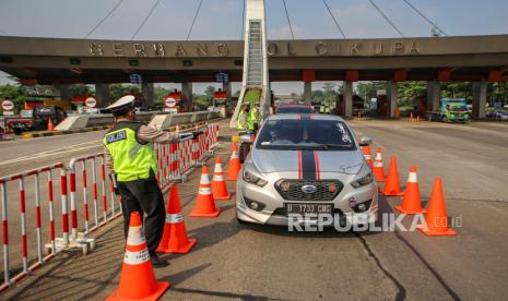 Petugas kepolisian memeriksa kendaraan di gerbang tol Cikupa, Kabupaten Tangerang, Banten, Selasa (19/5/2020). Pemeriksaan kendaraan tersebut sebagai tindak lanjut atas imbauan untuk tidak mudik dan Pembatasan Sosial Berskala Besar (PSBB) guna memutus mata rantai penyebaran COVID-19