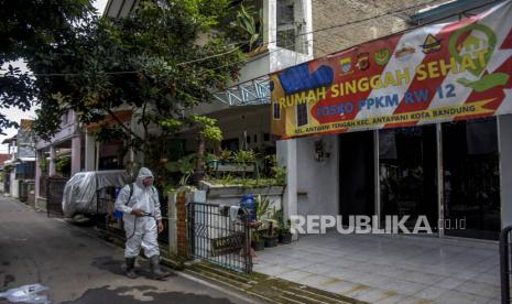 Warga menggunakan alat pelindung diri menyemprotkan cairan disinfektan di area Rumah Singgah Sehat di Jalan Kuningan, Antapani, Kota Bandung, Rabu (9/2/2022). Pemerintah Kota Bandung menyiapkan tempat isolasi mandiri (Isoman) bagi pasien Covid-19 atau keluarga pasien Covid-19 di 30 kecamatan guna mengantisipasi kasus Covid-19 yang terus mengalami kenaikan. Foto: Republika/Abdan Syakura