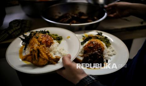 Pramusaji meyiapkan makanan di Rumah Makan Padang Surya Minang, Cikini, Jakarta, Selasa (10/1/2023). Rumah Makan Padang Surya Minang menyediakan beragam menu masakan khas Padang seperti Rendang kering, ayam gulai, ayam pop, kikil, lele, dan telor balado. selain menu utama, sambal lado ijo menjadi pelengkap menu andalan disetiap rumah makan Padang. Harga satu porsi masakan Padang bervariasi, mulai dari Rp15 ribu hingga Rp25 ribu. 