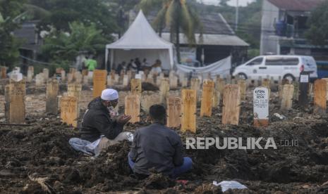 Warga berdoa saat berziarah di makam pasien Covid-19 di TPU Srengseng Sawah Dua, Jagakarsa, Jakarta, Jumat (12/3). Gubernur DKI Jakarta Anies Rasyid Baswedan mengatakan, ziarah kubur akan ditiadakan selama Idul Fitri 1442 Hijriah.