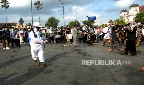 Peserta aksi dengan APD menyemprot disinfektan saat unjuk rasa di Titik Nol Yogyakarta, Jumat (21/5). Aksi dari Forum Umat Islam ini untuk mengecam keras agresi Zionis Israel ke Masjidil Aqsa Palestina. Dalam aksi ini selain orasi juga penggalangan dana, shalat ghaib untuk syuhada, dan qunut nazilah saat Shalat Ashar berjamaah.