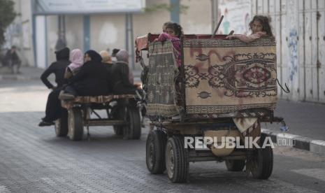 Warga Palestina meninggalkan rumah mereka setelah semalam serangan rudal berat Israel di lingkungan mereka di pinggiran Kota Gaza, Jumat, 14 Mei 2021.