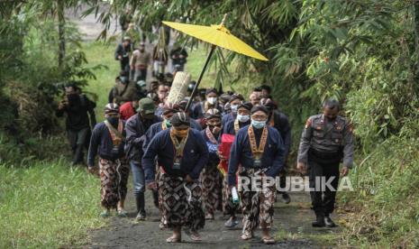 Abdi dalem Keraton Yogyakarta membawa uba rampe menuju Bangsal Srimanganti saat prosesi Labuhan Merapi di Sleman, DI Yogyakarta, Senin (15/3/2021). Upacara Labuhan Merapi merupakan rangkaian Tinggalan Dalem Jumenengan atau bertahtanya Sri Sultan HB X sebagai Raja Keraton Yogyakarta itu digelar secara terbatas karena status Siaga Merapi dan pandemi COVID-19.