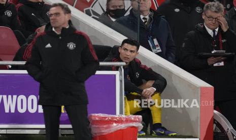 Pemain Manchester United Cristiano Ronaldo duduk menonton pertandingan setelah diganti dalam pertandingan sepak bola Liga Premier Inggris antara Brentford dan Manchester United di Brentford Community Stadium di London, Kamis (20/1/2022).