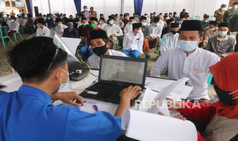 Petugas membantu pengisian formulir sebelum menyuntikkan vaksin COVID-19 AstraZeneca kepada santri Pondok Pesantren Lirboyo di Kota Kediri, Jawa Timur, Selasa (23/3/2021). Seluruh santri Pondok Pesantren Lirboyo ditargetkan mendapatkan suntikan vaksin Astrazeneca sebelum bulan ramadan sebagai upaya menanggulangi penyebaran COVID-19 di lingkungan pesantren.