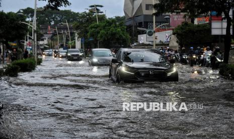 Pengendara menerobos genangan air (ilustrasi). BMKG memprediksi puncak musim hujan di Jakarta berlangsung November 2024 hingga Februari 2025.