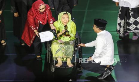 Istri Presiden ke-4 RI Sinta Nuriyah (tengah) mewakili Presiden ke-4 RI Abdurrahman Wahid menerima penghargaan kategori nasional yang diberikan oleh Ketua PBNU KH Yahya Cholil Staquf (kanan) saat Anugerah Satu Abad NU di Theater Indonesia, TMII, Jakarta, Selasa (31/1/2023) malam. Pengurus Besar Nahdlatul Ulama (PBNU) menggelar malam Anugerah Satu Abad NU sebagai ajang pemberian penghargaan kepada pihak-pihak yang berjasa dalam membesarkan NU. 