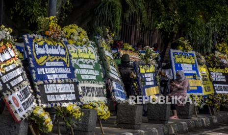 Sejumlah warga beraktivitas di dekat deretan karangan bunga ucapan belasungkawa atas wafatnya Wali Kota Bandung Oded M Danial di Jalan Dalem Kaum, Kota Bandung, Ahad (12/12). Ratusan karangan bunga tersebut sebagai bentuk penghargaan, penghormatan sekaligus duka cita atas wafatnya Wali Kota Bandung Oded M Danial pada Jumat (10/12). Foto: Republika/Abdan Syakura